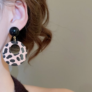 Detailed close-up of leopard print hollow hoop earring with stylish black spherical stud