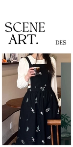 Detail of black cotton linen apron featuring elegant floral embroidery in a cafe setting