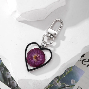Handmade heart-shaped keychain with dried purple flower in resin and silver metal ring
