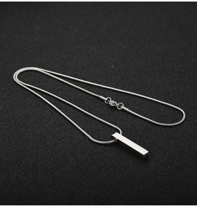 Close-up of a 3D silver stainless steel pillar pendant on a sleek snake chain necklace