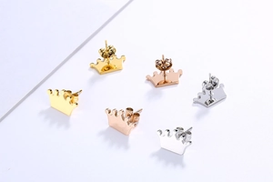 Detailed view of crown stud earrings in gold, rose gold, and silver finishes