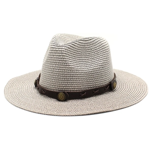 Détail d'un chapeau de paille avec bande en cuir marron et boucle en métal rétro