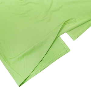 Detail view of double-stitched side slit on a lime green knit dress with clean seams