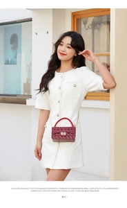 Detail of burgundy lattice jelly bag featuring woven handle and gold metal twist lock closure