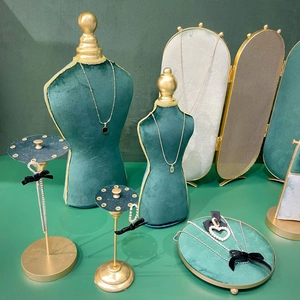 Dark green velvet jewelry display set featuring necklace busts and accessory trays