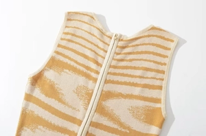 Dettaglio del vestito in maglia giallo e beige con cerniera posteriore e scollo rotondo