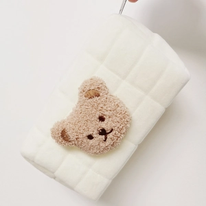 Detail of white plush pencil case with brown bear embroidery and quilted pattern