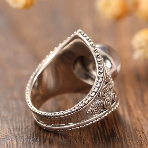 Détail macro de la bague vintage en pierre de lune avec oxydation et motifs de fleurs