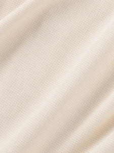 Detailed macro view of cream waffle weave fabric texture on men's casual summer shirt