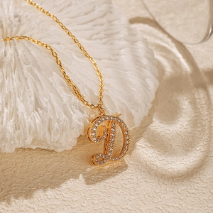 Detail of 18K gold plated letter D pendant with sparkling zircon inlays and O-chain