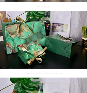 Detail of dark green marble gift bags with golden textures and satin ribbons