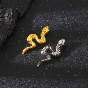 Macro shot showing gold and silver snake pendants with detailed scale textures