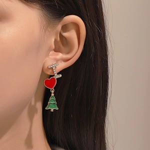 Detailed view of Christmas earrings with red heart, green tree, and rhinestone letter I