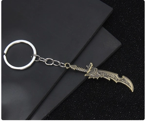 Detail of bronze metal sword model keychain on a professional black matte background