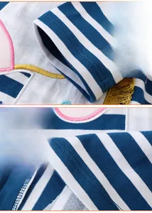 Close-up of cotton knit dress showing striped fabric texture and yellow fringe tassels