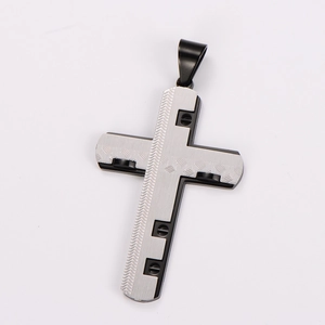 Close-up of silver and black cross pendant with wave texture and screw details