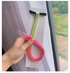 Detail of yellow-green to rose red gradient braided hair extension with elastic band