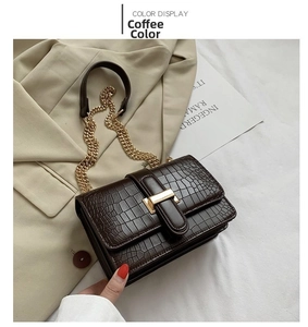 Close-up of coffee brown crocodile pattern leather bag with golden metallic buckle