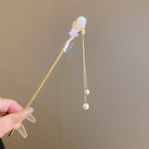 Détail d'un pic à cheveux avec pampilles de perles et design de tulipe dorée