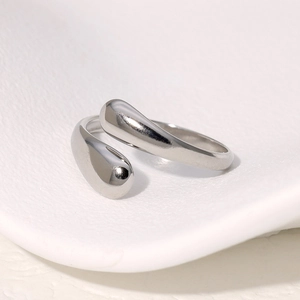 Minimalist open stainless steel ring with elegant water drop design on ceramic background