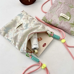 Detail of jacquard butterfly crossbody bag with colorful woven strap and cord lock