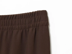 Vue détaillée de la taille élastique d'un pantalon marron foncé avec coutures précises