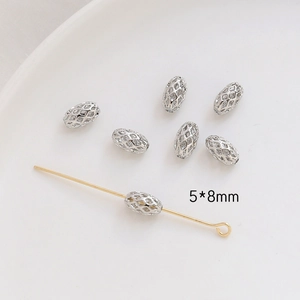 Macro detail of 5x8mm hollow silver beads and gold T-pin jewelry making components