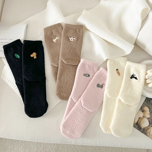 Detailed view of four pairs of warm plush socks with cute animal embroidery patterns