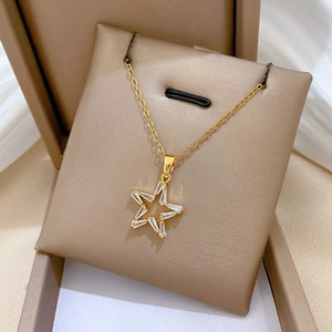 Detail of gold star pendant necklace with sparkling cubic zirconia in jewelry box
