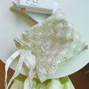Close-up of light green canvas tote bag featuring floral patterns and a cute sheep print