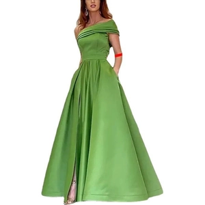 Détail d'une robe de soirée en satin vert avec fente haute et poches latérales