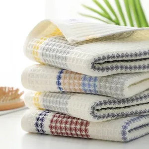 Set of four cotton waffle weave towels with colorful stripes and honeycomb texture