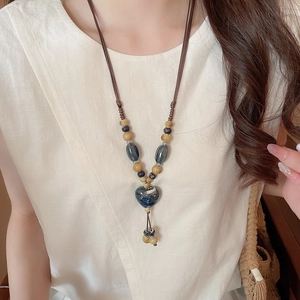 Détail du pendentif cœur en céramique bleue sur un collier ethnique tissé à la main