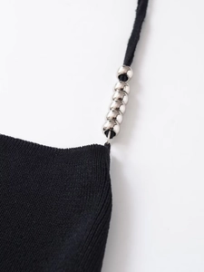 Detail of black ribbed knit top with silver metal beads on adjustable shoulder straps