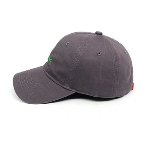 Close-up of dark grey baseball cap with green mood embroidery and red side label