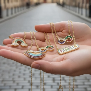 Detailed shot of golden necklaces with rainbow, red lips, and Familia pendants