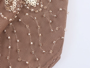 Close-up of brown mesh fabric with gold sequins and beads detailing for festival tops