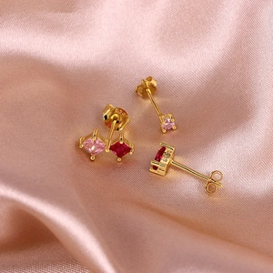 Macro shot of S925 sterling silver trinity earrings set with pink and red square crystals