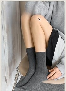 Detailed texture of dark grey ribbed combed cotton socks in a cozy home setting
