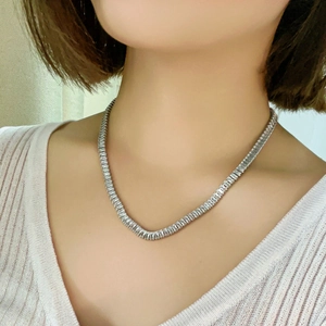 Elegant silver tennis necklace with square cut colorful zircon stones worn by a model