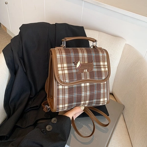 Vintage checkered backpack with dachshund embroidery and brown PU leather trim on sofa