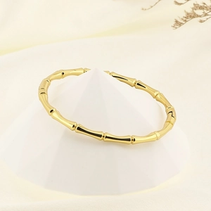 Polished 18K gold plated stainless steel bamboo cuff bracelet on pyramid display stand