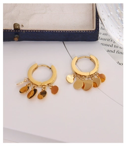 Detailed macro view of 18k gold plated titanium geometric disc dangle hoop earrings