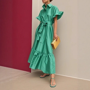 Détail de la robe verte à manches à volants avec ceinture et ourlet élégant