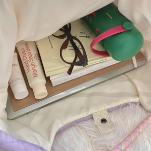 Macro shot of spacious interior in quilted tote bag filled with daily essentials