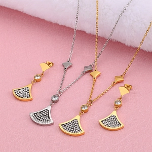 Elegant gold and silver rhinestone jewelry sets with fan pendants and earrings on pink decor