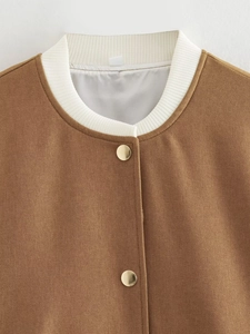 Close-up of white ribbed collar and gold metallic snap buttons on brown bomber jacket
