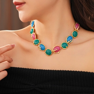 Détail d'un collier vintage doré avec des pierres ovales colorées sur un mannequin