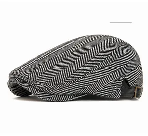 Dettaglio della coppola in tweed grigio chiaro con cinturino in pelle e fibbia