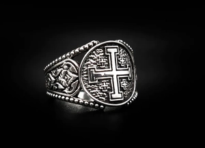 Close-up of vintage stainless steel ring with engraved Jerusalem cross and scroll patterns